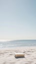 Book resting on sandy beach by tranquil ocean under clear blue sky Royalty Free Stock Photo