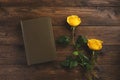 Book and roses, isolated on wooden background