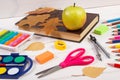 Book, school accessories and autumnal leaves on white boards, back to school concept Royalty Free Stock Photo