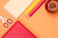 Book, scissors, notebook, color pencils and red apple on pink ba Royalty Free Stock Photo