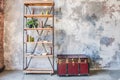 Book shelf and wooden chest in front of the grunge shabby gray wall