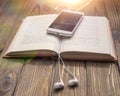 Book smartphone headphones on a wooden background. audiobook