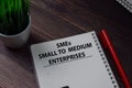 Book about SMEs - Small To Medium Enterprises isolated on wooden table
