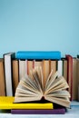 Book stacking. Open book, hardback books on wooden table and blue background. Back to school. Copy space for text Royalty Free Stock Photo