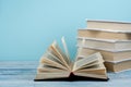 Book stacking. Open book, hardback books on wooden table and blue background. Back to school. Copy space for text Royalty Free Stock Photo