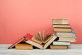 Book stacking. Open book, hardback books on wooden table and pink background. Back to school. Copy space for text Royalty Free Stock Photo