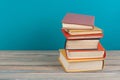 Book stacking. Open hardback books on wooden table and blue background. Back to school. Copy space for ad text Royalty Free Stock Photo