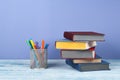 Book stacking. Open book, hardback books on wooden table and blue background. Back to school. Copy space for text Royalty Free Stock Photo