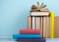 Book stacking. Open book, hardback books on wooden table and blue background. Back to school. Copy space for text Royalty Free Stock Photo