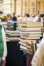 Book stacks on wood desk blurred people in bookstore, reading, hobby, second-hand books concept