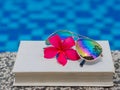 Book and sunglasses, blue water background Royalty Free Stock Photo