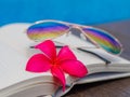 Book and sunglasses, blue water background Royalty Free Stock Photo