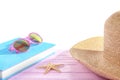 Book, sunglasses and hat on pink table