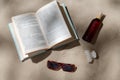 book, sunglasses and sunscreen on beach sand Royalty Free Stock Photo