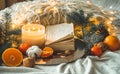 Book and Tangerines in a winter composition, Christmas trees, candles, cones, cotton, cinnamon. Symbol of New Year and Christmas Royalty Free Stock Photo
