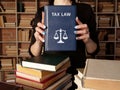 Book with title TAX LAW . It covers the rules, policies and laws that oversee the tax process, which involves charges on estates, Royalty Free Stock Photo