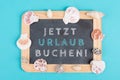 Book vacation now is standing in german language on the chalkboard, seashells bulit frame, holiday and summertime topic, travel