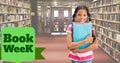Book week text over portrait of smiling biracial elementary girl standing with books in library Royalty Free Stock Photo