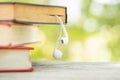 Book and white earphone on wooden table with abstract green nature blur background. Reading and education concept