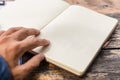 A book on wood table and open by man hand