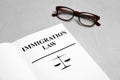 Book with words IMMIGRATION LAW and glasses Royalty Free Stock Photo