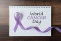 Book with WORLD CANCER DAY text and lavender ribbon Royalty Free Stock Photo