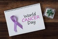 Book with WORLD CANCER DAY text and lavender ribbon Royalty Free Stock Photo