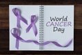 Book with WORLD CANCER DAY text and lavender ribbon Royalty Free Stock Photo