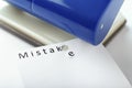 Bookbinder and paper with printed word MISTAKE on white background, closeup