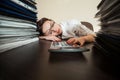 Bookkeeper asleep against big stacks of documents