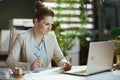 bookkeeper woman in light business suit in green office