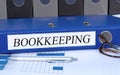 Bookkeeping - blue binder with text in the office Royalty Free Stock Photo