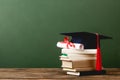 Books, academic cap and diploma on wooden surface Royalty Free Stock Photo