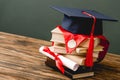 Books, academic cap, medal and diploma on on grey
