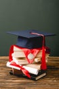 Books, academic cap, medal and diploma on wooden