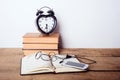 Books, alarm clock, notepad, cellphone on wooden background