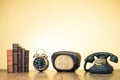 Books, alarm clock, old radio, retro telephone on wooden table. Vintage style photo