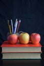 Books and an Apple on a black background. Royalty Free Stock Photo
