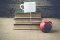 Books and apple with coffee cup on retro background with Instag Royalty Free Stock Photo