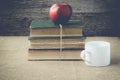 Books and apple with coffee cup on retro background with Instag Royalty Free Stock Photo