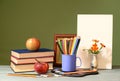 Books, apples, colored pencils and painting canvas