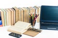 Books background, open book, laptop, smartphone, glasses and pencils holder on white wooden table in office for education learning Royalty Free Stock Photo