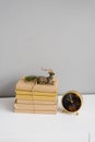 Books in beige paper cover, on which there is a statuette of a sitting deer and a sprig of a Christmas tree lies, next to the tabl