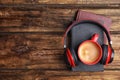 Books, coffee and headphones on wooden table. Space for text