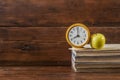 Books, fresh green apple and alarm clock on vintage wooden background Royalty Free Stock Photo