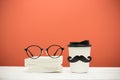 Books, glasses and cup with mustache