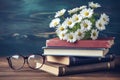 Books, glasses and daisies on wooden table. Education background