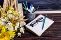 Books, glasses, markers and a bouquet of flowers in a vase on white board background. Concept for teachers day and first September