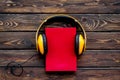 Books with headphones for listening to audiobook on wooden background top view