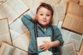 On the books lies a little boy in a plaid shirt and blue trousers with suspenders. Concept for a bookstore. Books are knowledge.